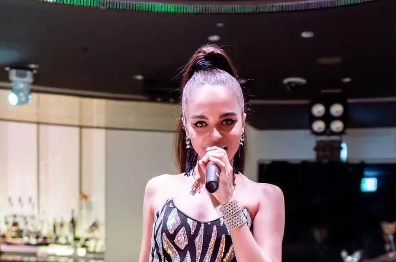 Singer in a black and silver gown performing in a hotel bar